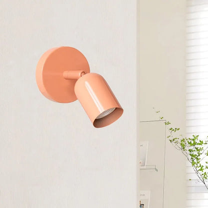 Applique murale minimaliste métal installée au-dessus d'une tête de lit, décor cosy et moderne