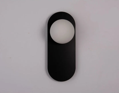 Lampe de chevet murale ovale minimaliste installée au-dessus d'un lit dans une chambre moderne