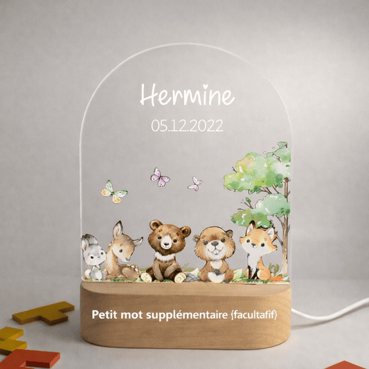 Veilleuse naissance personnalisée forêt papillons avec prénom gravé posée dans une chambre de bébé