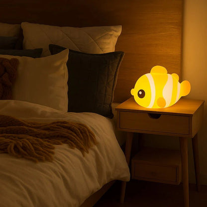 Veilleuse enfant poisson clown posée sur une table de chevet dans une chambre enfant